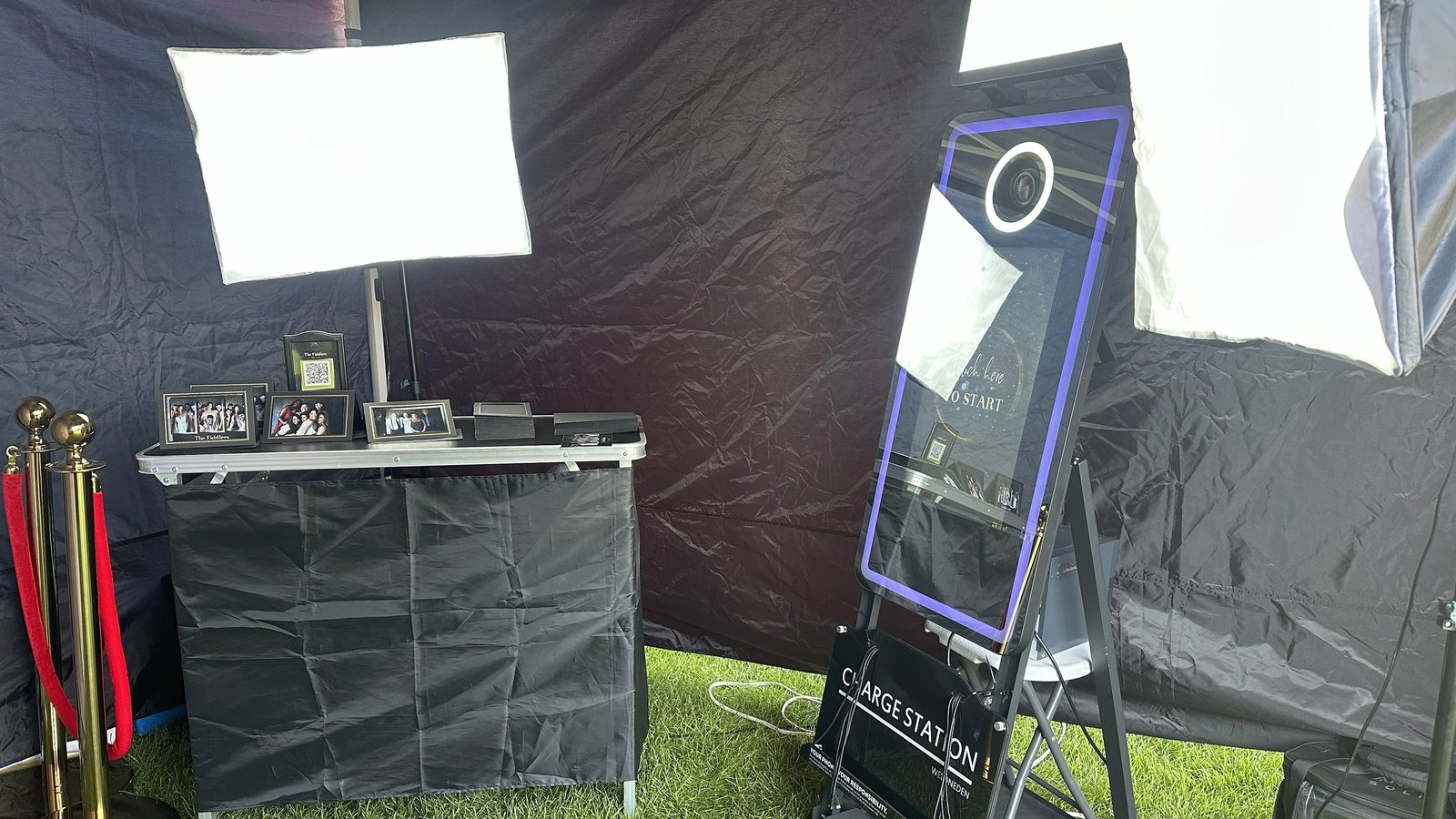 The Raven's Occasions mirror photo booth set up under its canopy with softbox lighting and a signing table