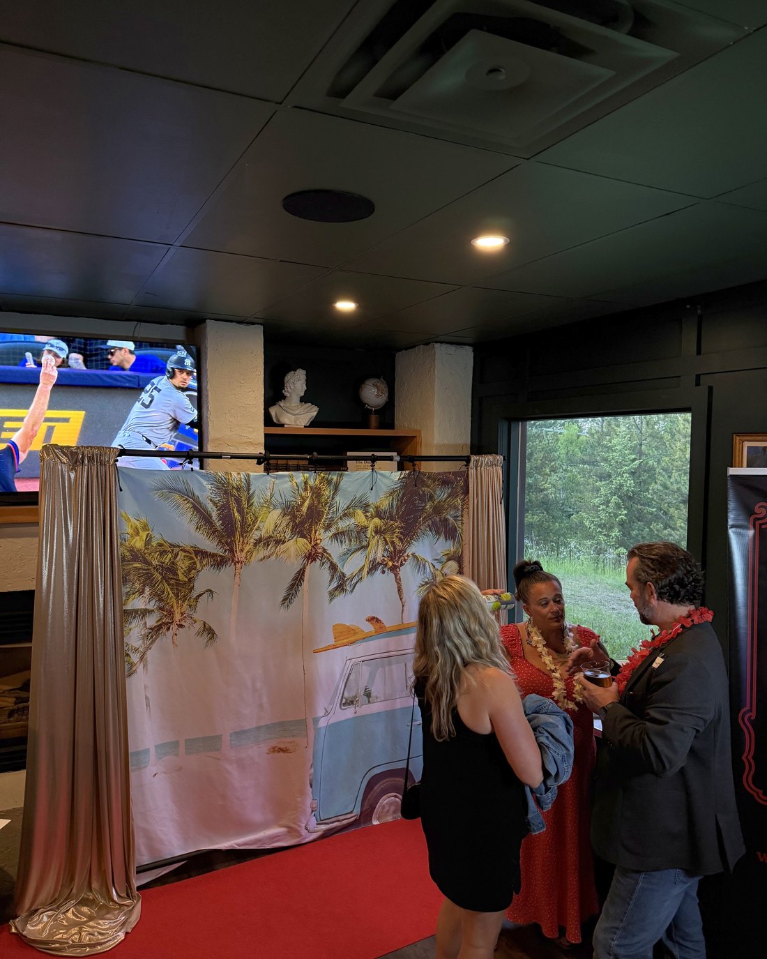Guests at the mirror photo booth backdrop during an evening event