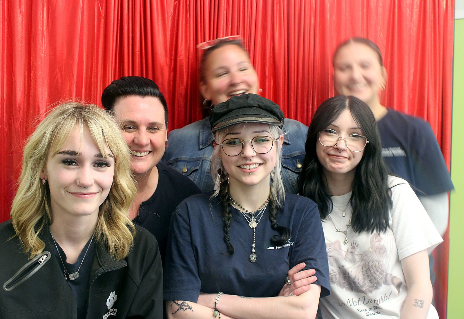 Five friends crowded shoulder to shoulder in front of the red curtain at the Humane Society fundraiser