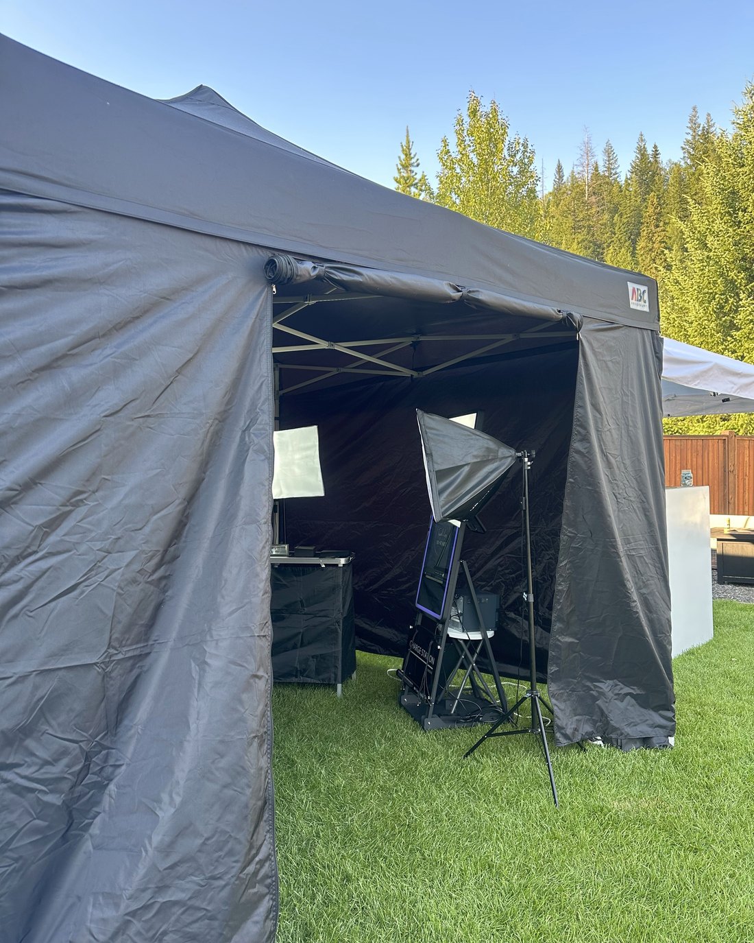 The mirror photo booth set up outdoors under its canopy with red rope stanchions